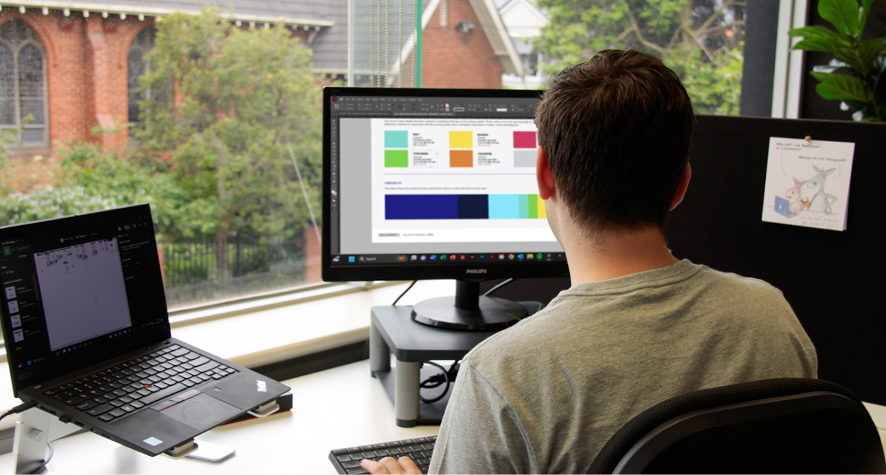 Over-the-shoulder shot of workstation at MOO's graphic design agency in Melbourne