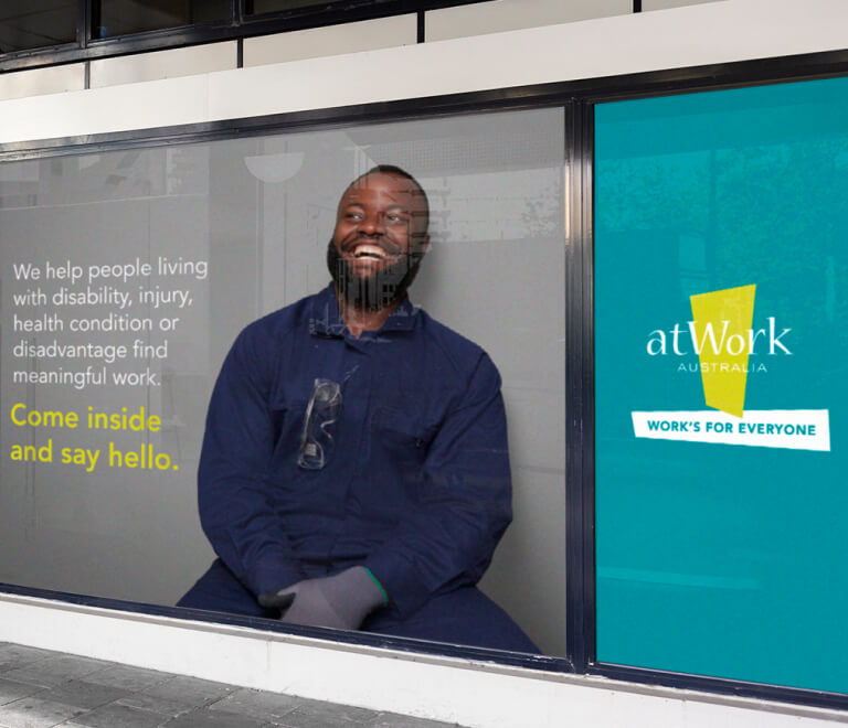 Bus station ad for atWork Australia featuring smiling man next to block quote