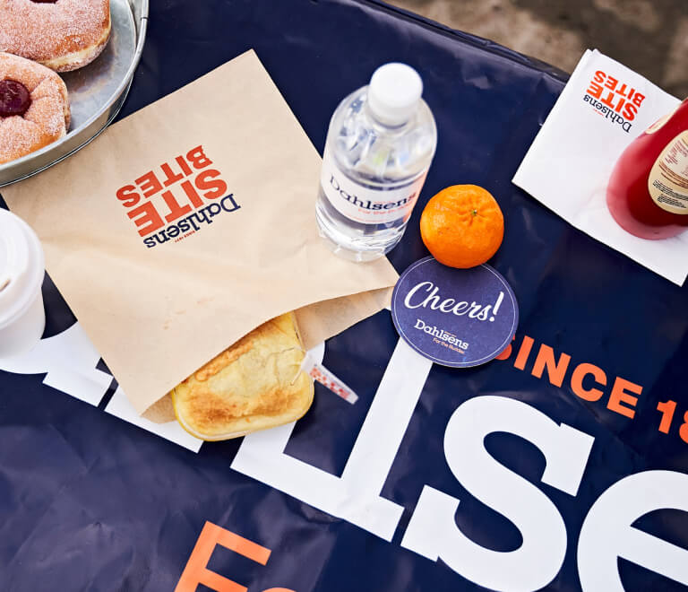 Range of Dahlsens brand collateral including tablecloth, paper bag, water bottle, napkins