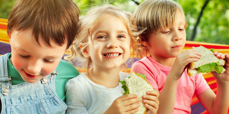 Advertisement featuring three smiling children eating Grainbow bread